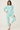 Woman wearing a blue pajama set with cupcake pattern on a white background