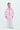 Person wearing a pink jacket with a visible brand logo on a white background