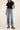Person wearing a navy t-shirt and blue jeans on a plain background