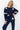Woman wearing a navy blue outfit with white star patterns on a white background
