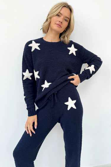 Woman wearing a navy blue outfit with white star patterns on a white background