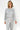 Woman wearing a gray pajama set with dog pattern on a white background