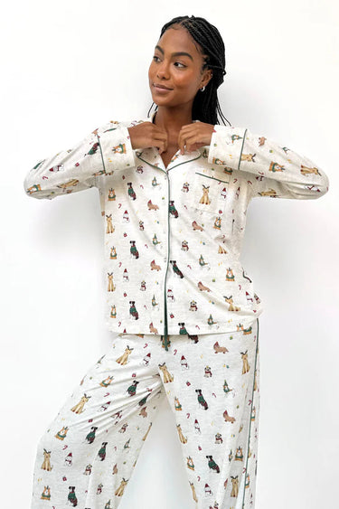 Woman wearing a white pajama set with animal prints on a white background