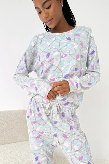 Person wearing a patterned pajama set on a white background