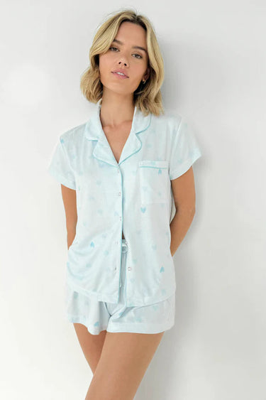 Woman wearing light blue pajama set against a white background
