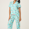 Woman wearing a blue pajama set with cupcake pattern on a white background