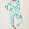 Woman wearing a blue pajama set with cupcake pattern on a white background