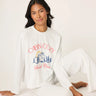 Woman wearing a white 'Cabin Core' sweatshirt and pants on a white background