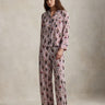 Woman wearing a patterned pajama set with red socks on a plain background