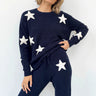 Woman wearing a navy blue outfit with white star patterns on a white background