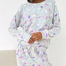 Person wearing a patterned pajama set on a white background